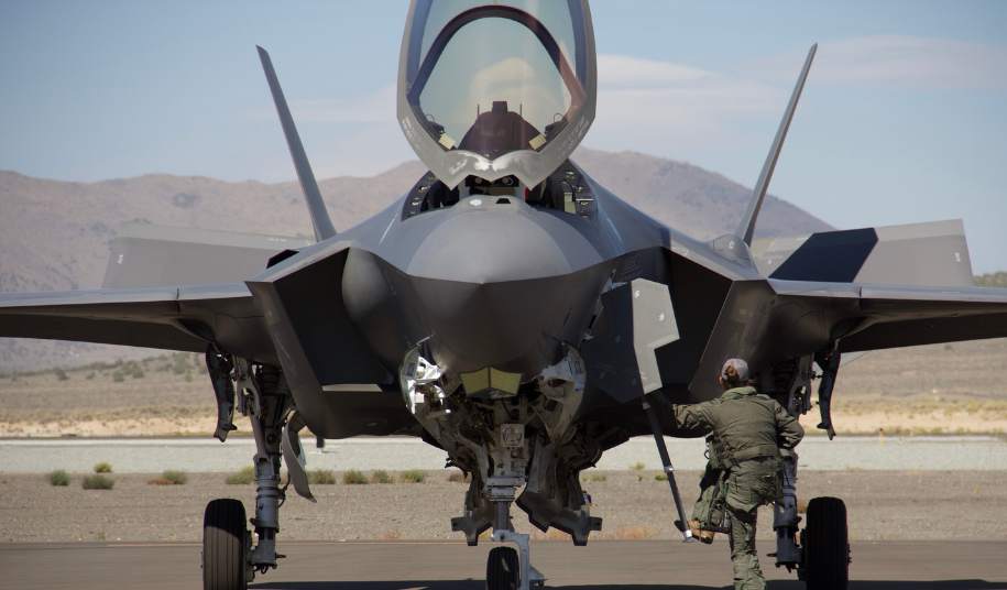 Fighter jet on runway with ground crew member, representing this week's defence sector focus